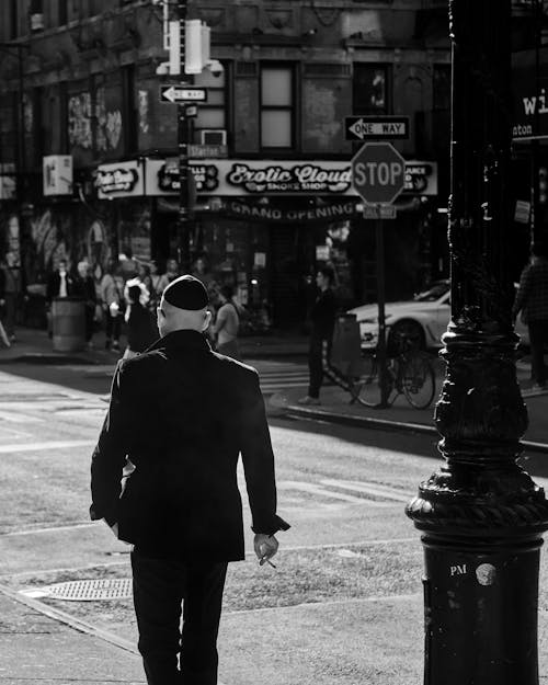 Free Grayscale Photo of a Man Walking on the Road Stock Photo
