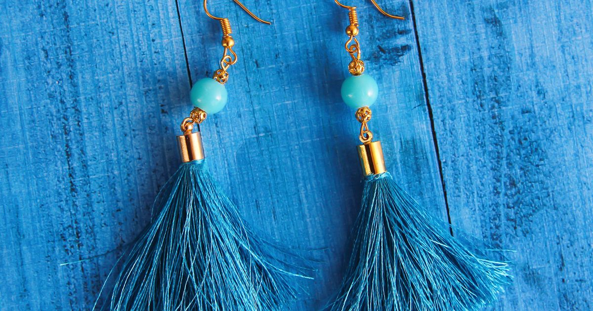 Close-up of a delicate pendant necklace on a simple gold chain against a neutral background