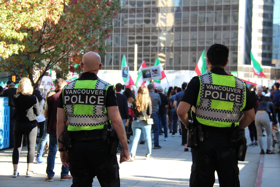 Back view of Vancouver police during a peaceful protest in the city center, showcasing community interaction.