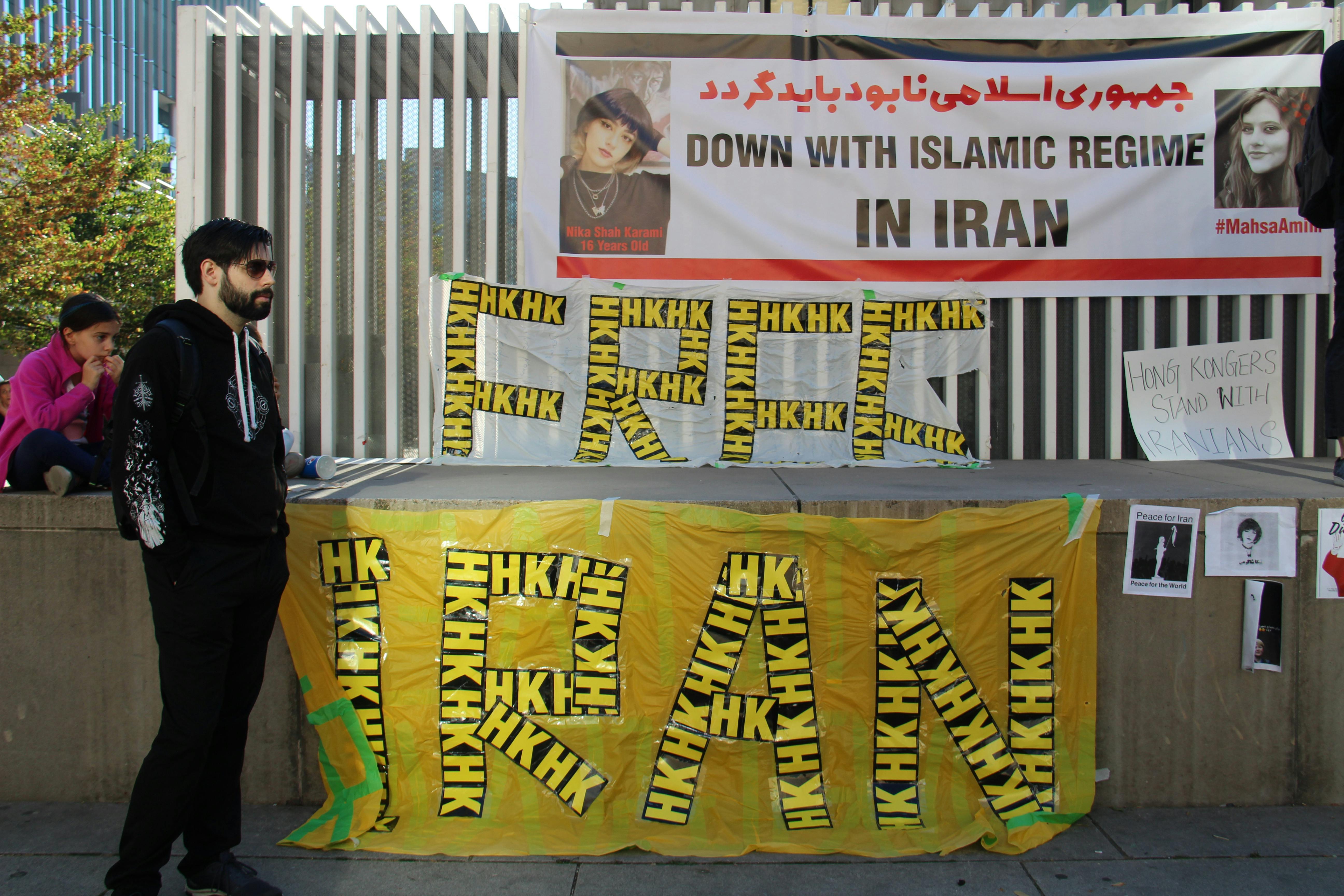 a protester standing beside banners at a demonstration