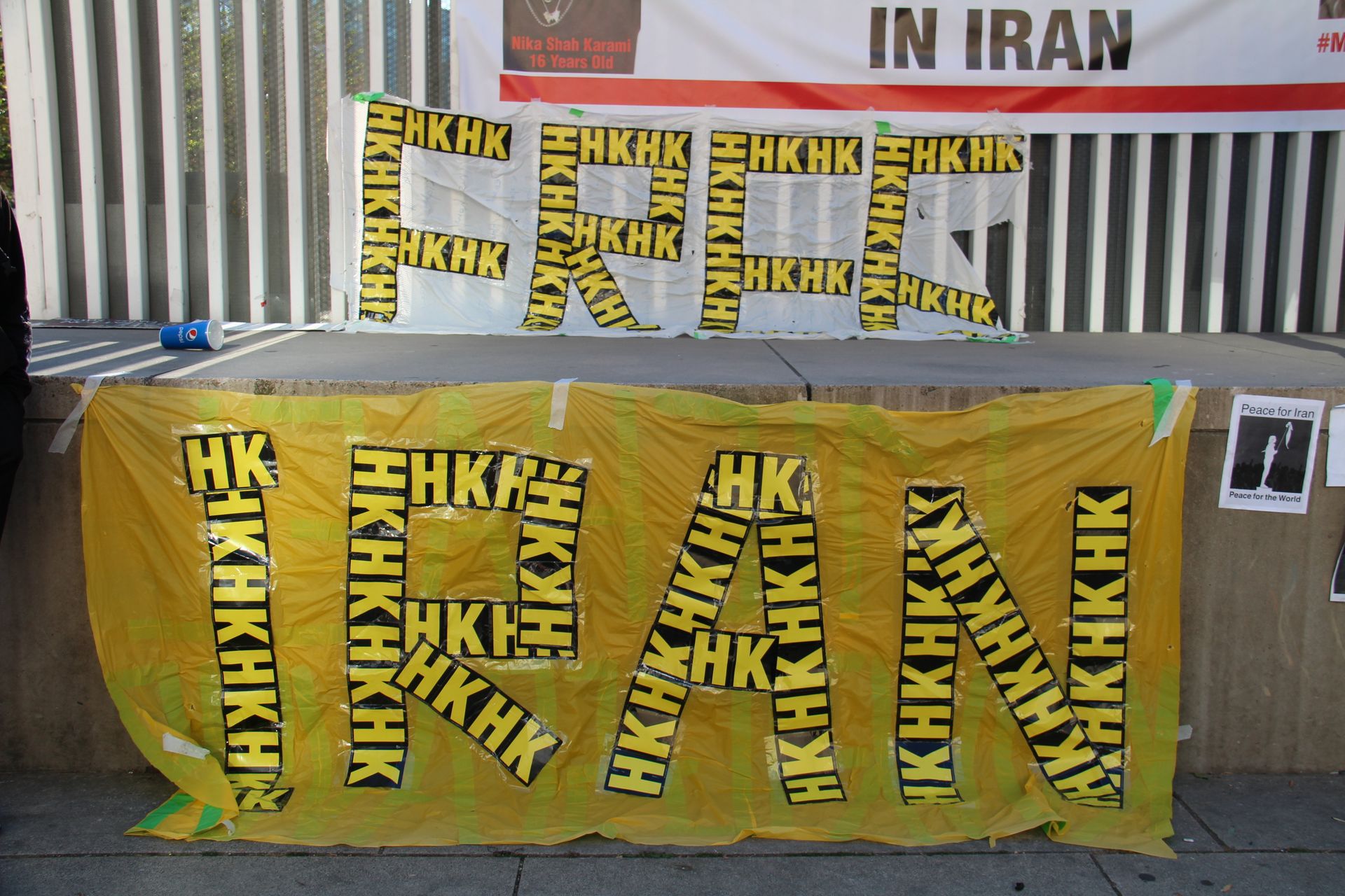 Vibrant protest banners advocating for human rights in Iran displayed outdoors, showcasing bold messages.