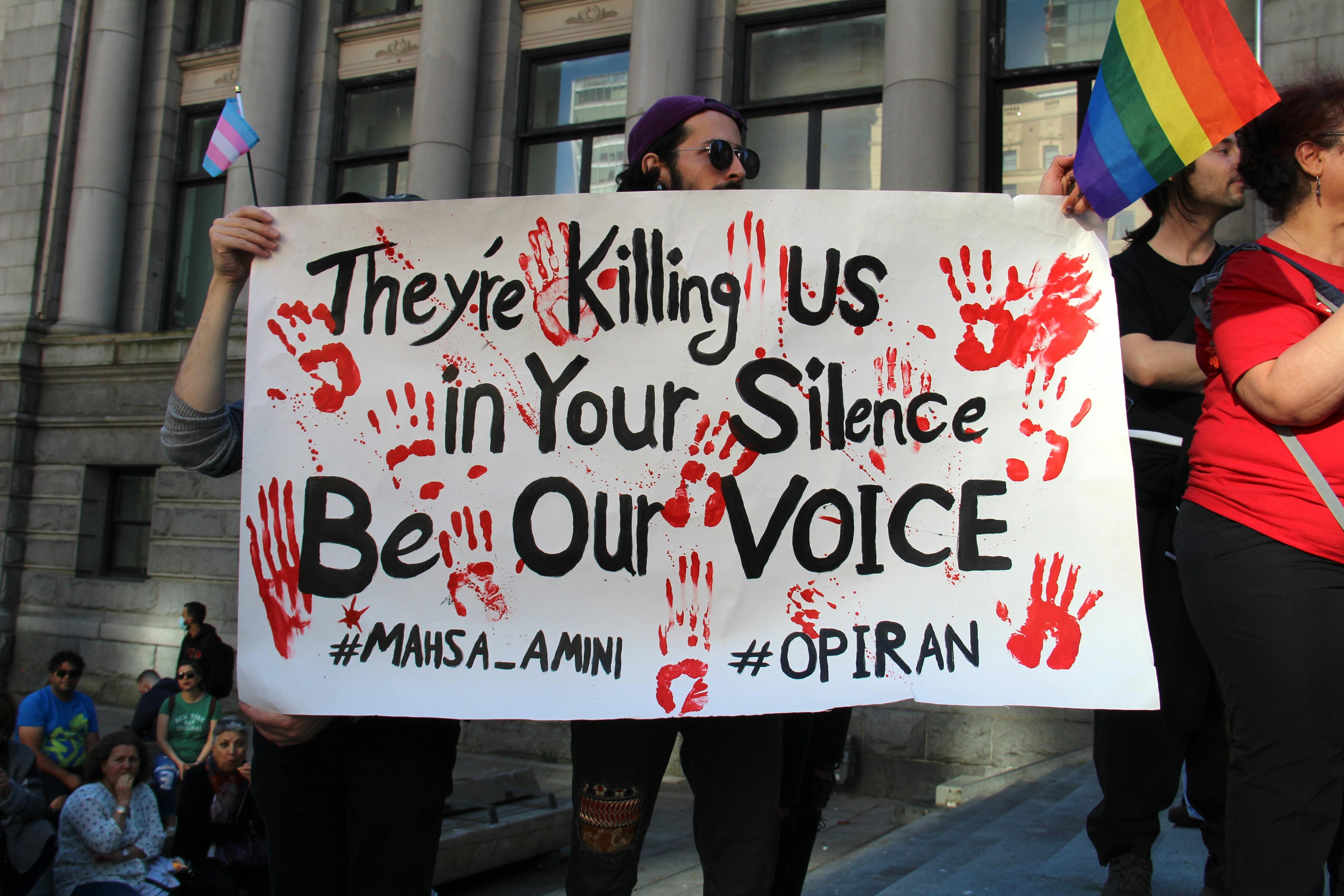 people protesting on street holding poster and flags