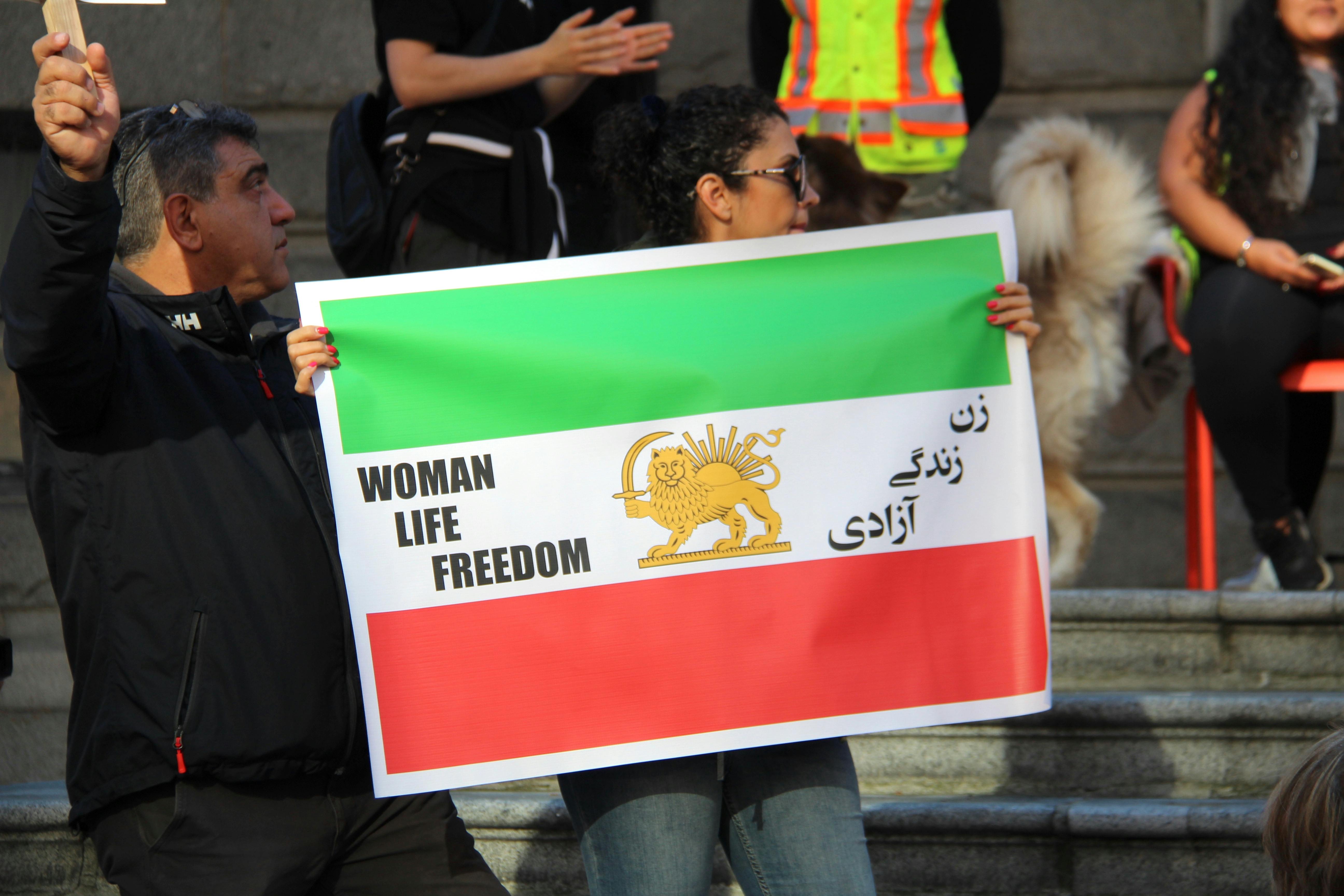 protesters holding the flag of iran