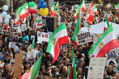 Crowd of People Protesting on Street Holding Flags and Posters