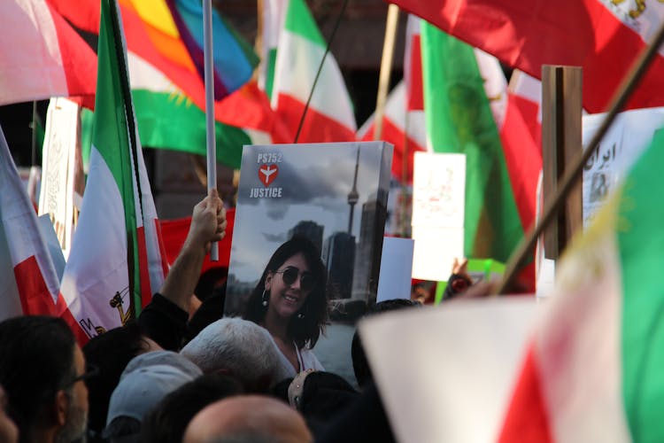 Crowd Of People Protesting On Street Holding Flags