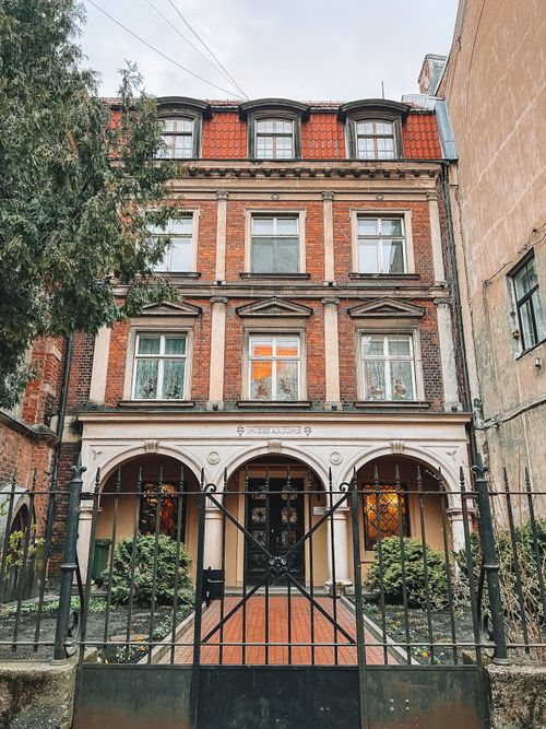 Free Charming brick building with metal gate and glass windows in Riga's historic district. Stock Photo
