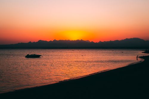 Free Beautiful silhouette of a boat during sunrise at Safaga beach, showcasing vibrant colors and serene waters. Stock Photo