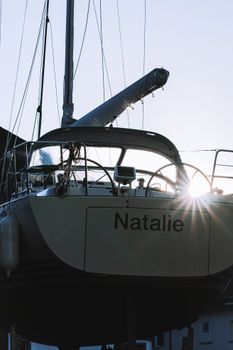 A sailboat named 'Natalie' docked at the marina during sunrise, showcasing serene nautical beauty.