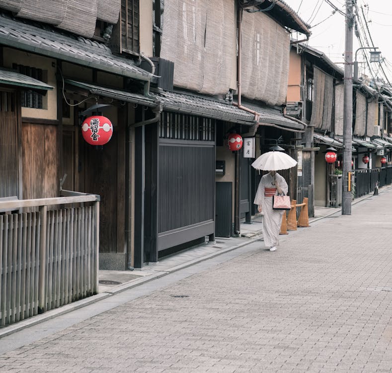 Free Woman Wearing White Kimono Dress Walking Near Road Stock Photo