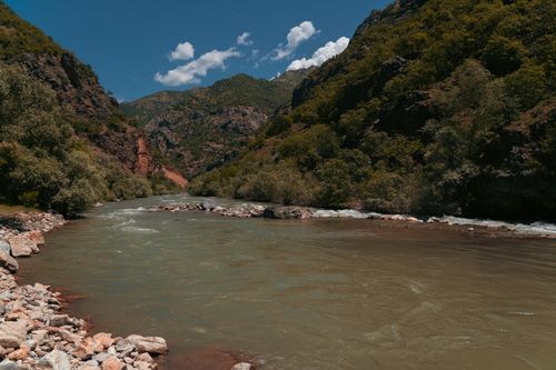 Free A scenic view of a river surrounded by lush green mountains in Tunceli, Türkiye. Stock Photo
