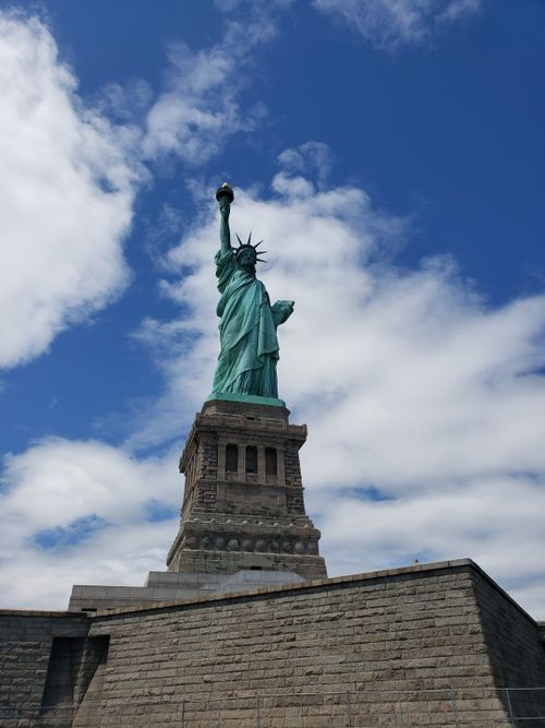 Free Iconic Statue of Liberty under blue skies in New York City. Stock Photo