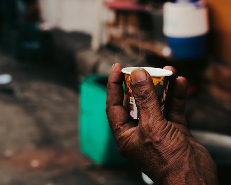 Close-up Of Old Man Hand Holding Cup With Hot Drink