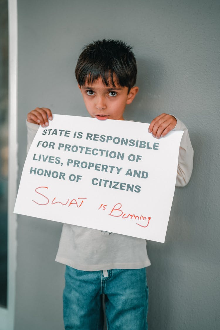 Boy Holding A Sheet Of Paper