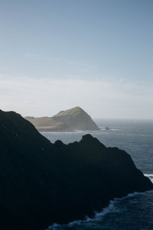 Free Majestic coastal cliffs meeting the ocean under a clear sky, creating a stunning scenery. Stock Photo