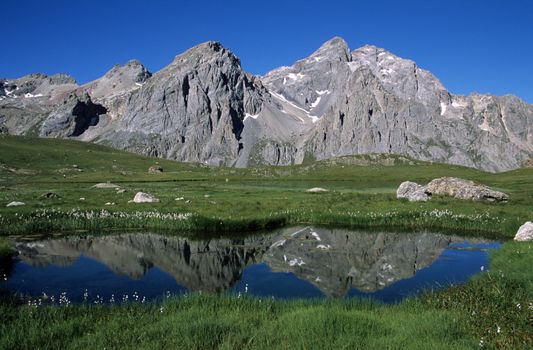 Breathtaking view of mountainous reflection in a tranquil lake in Le Bourg-d'Oisans, France.