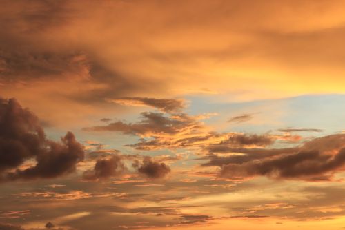Free A breathtaking view of dramatic golden clouds during sunset with a serene sky. Stock Photo