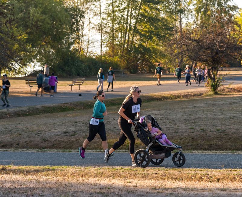 A group of people running outdoors in a park setting