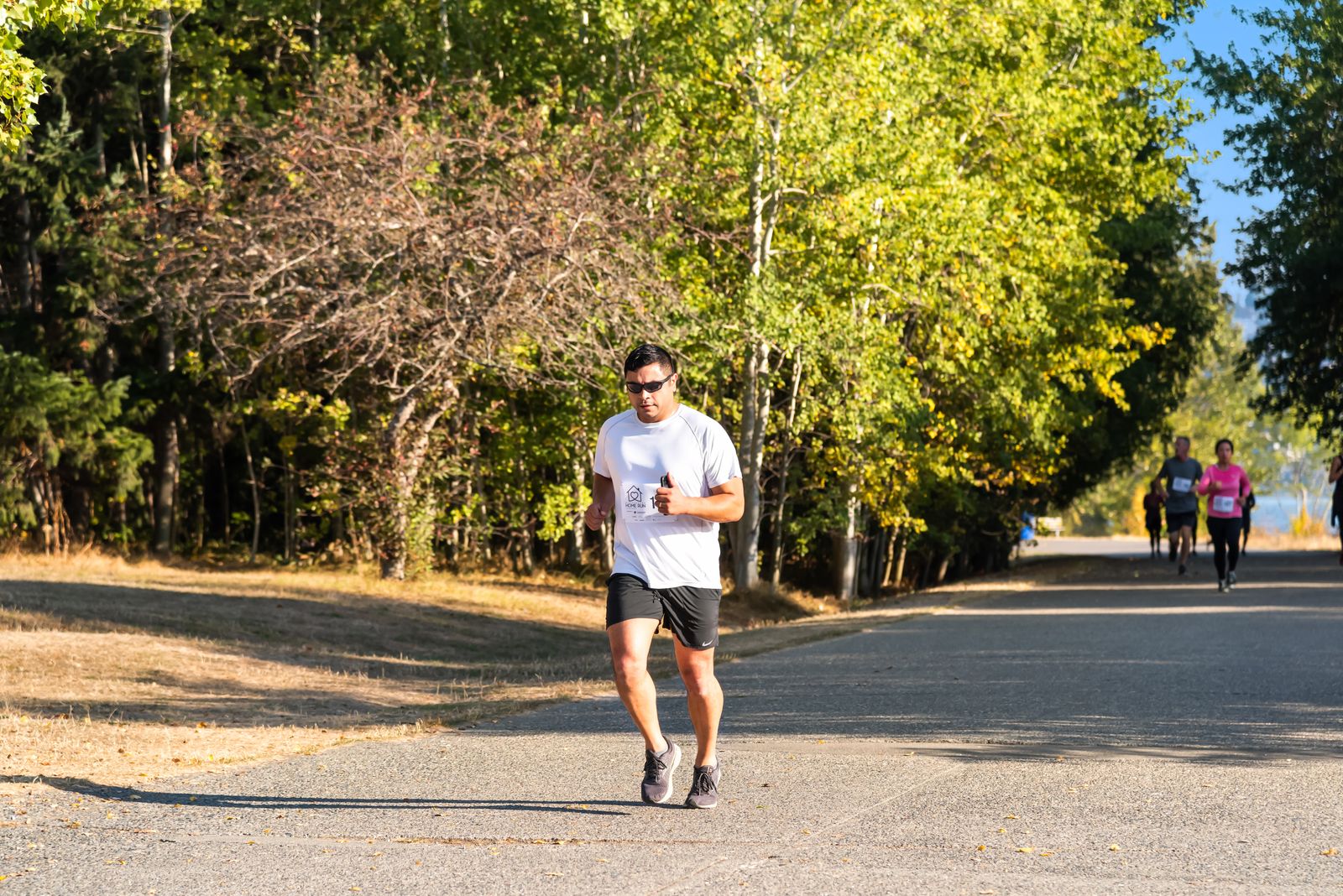 Runner stretching outdoors in bright daylight before using compression sleeves