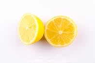 Close-up Photo of Sliced Yellow Lemon on White Surface