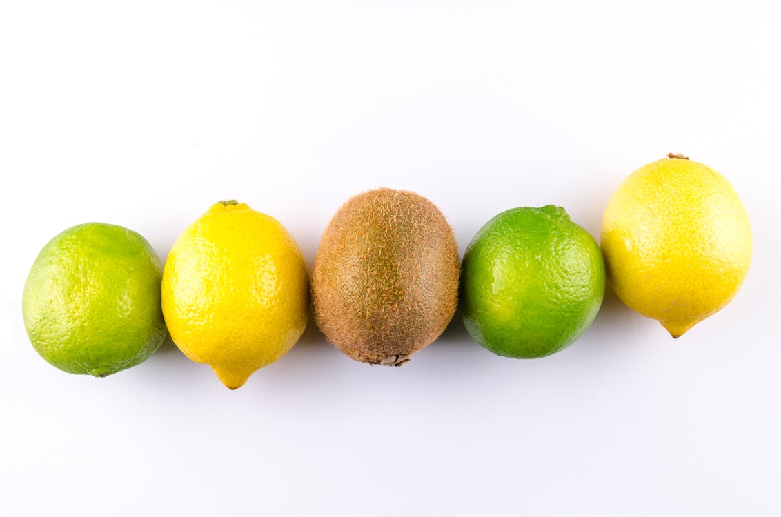 Flat Lay Photo of Two Lemon, Two Limes, and One Kiwi