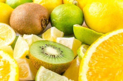 Close-Up Photography of Sliced Kiwi Near Lemons