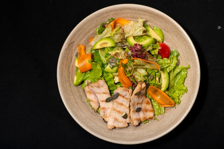 A Vegetable Salad With Chicken On Ceramic Bowl