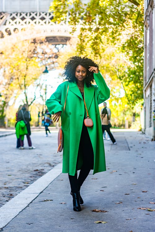 Woman in a Green Coat Posing in the City Street 