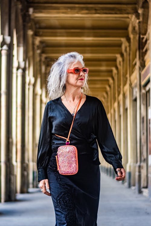 Elderly Woman in a Black Dress with a Pink Handbag