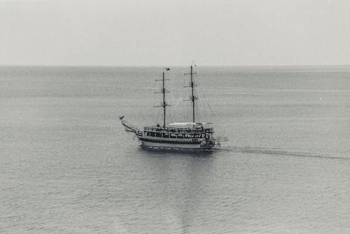 A Grayscale of a Ship in the Sea