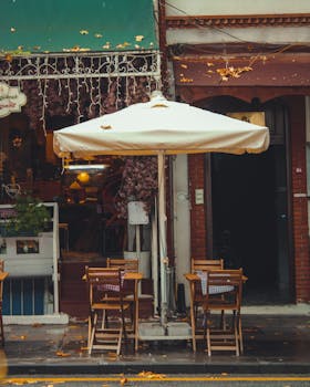Outdoor street café with autumn decor and vibrant leaves in İstanbul, Turkey.