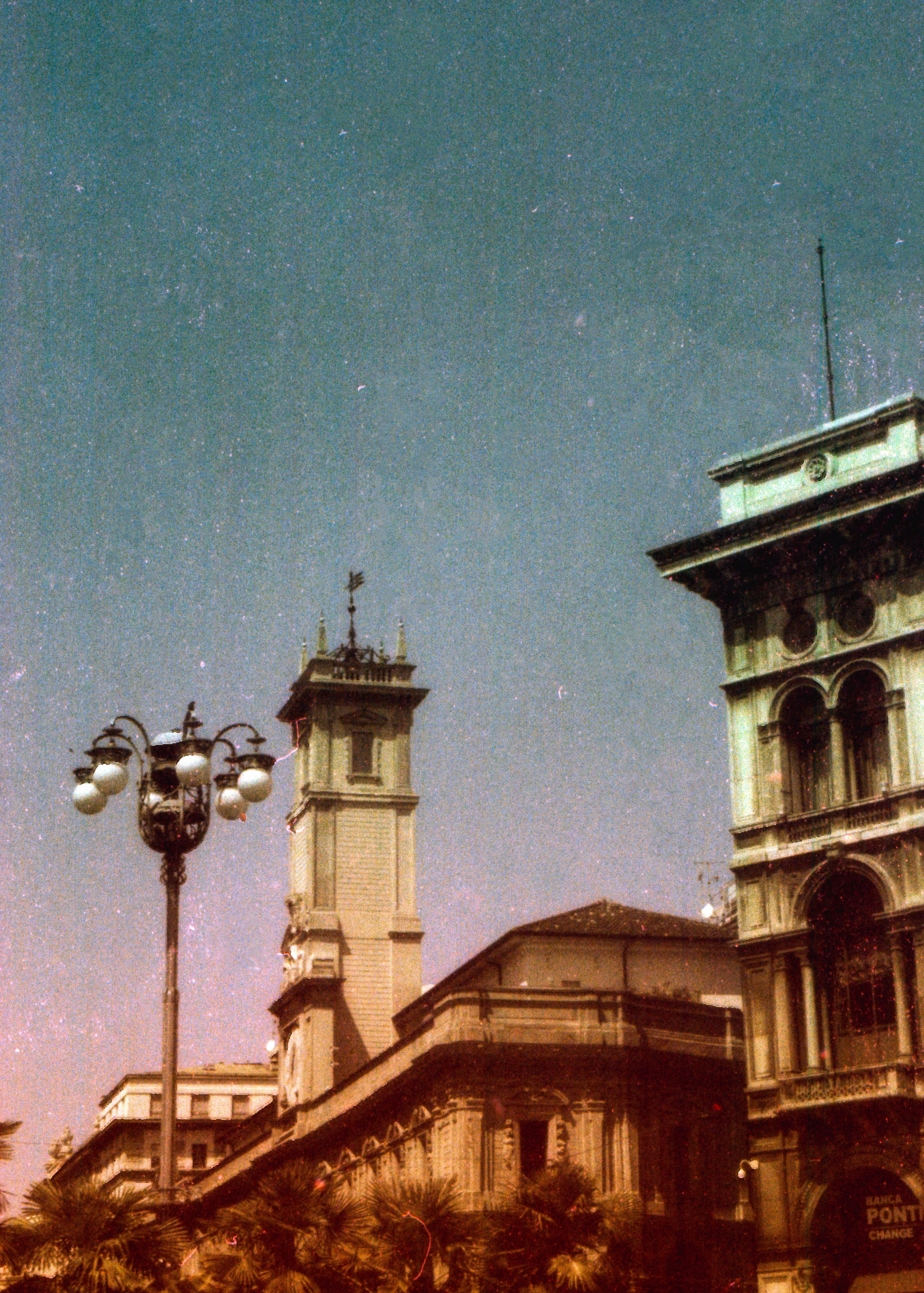 An analog photograph showcasing vintage architecture in Milan, Italy at night.