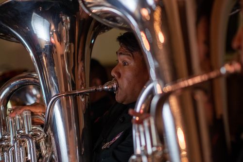Free Close-up of a musician playing a tuba at an indoor concert, highlighting the shiny brass instrument. Stock Photo