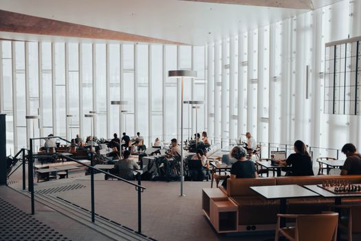 Spacious interior of Oslo public library with people reading and studying.