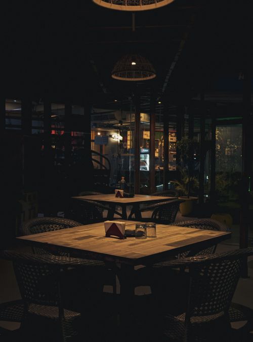 Free Warm and intimate restaurant interior with wooden furniture and subtle lighting. Stock Photo