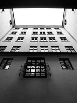 Grayscale view of a modern building courtyard in Oslo with tall windows.