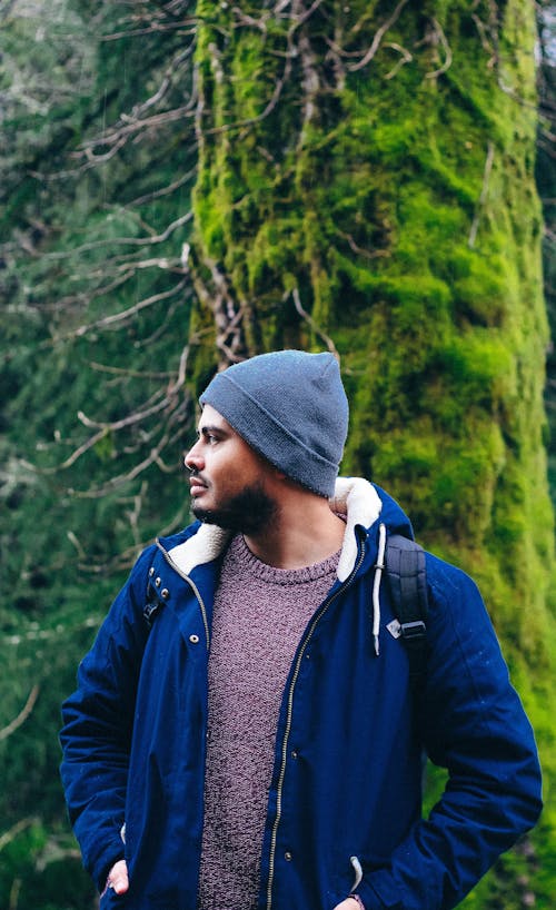 Photo of a Man in a Blue Jacket Looking Away