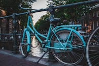 一辆经典蓝色自行车停在荷兰阿姆斯特丹的运河桥上，展现着城市魅力