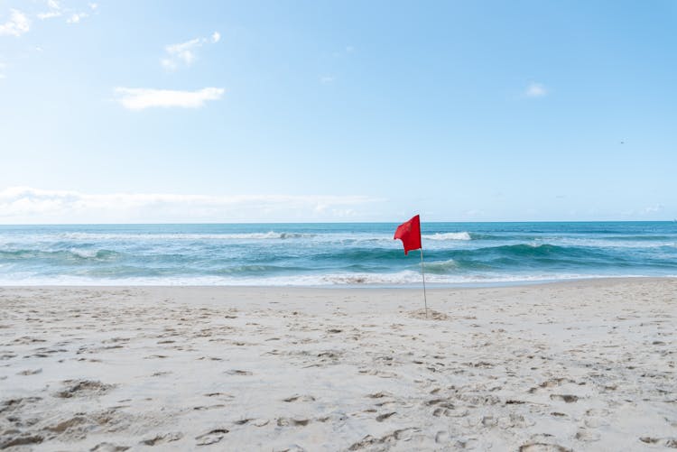 Red Flag On An Empty Sandy Beach 