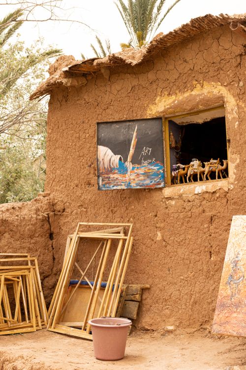 Free A charming clay cottage displays art and sculptures in a rural setting under daylight. Stock Photo