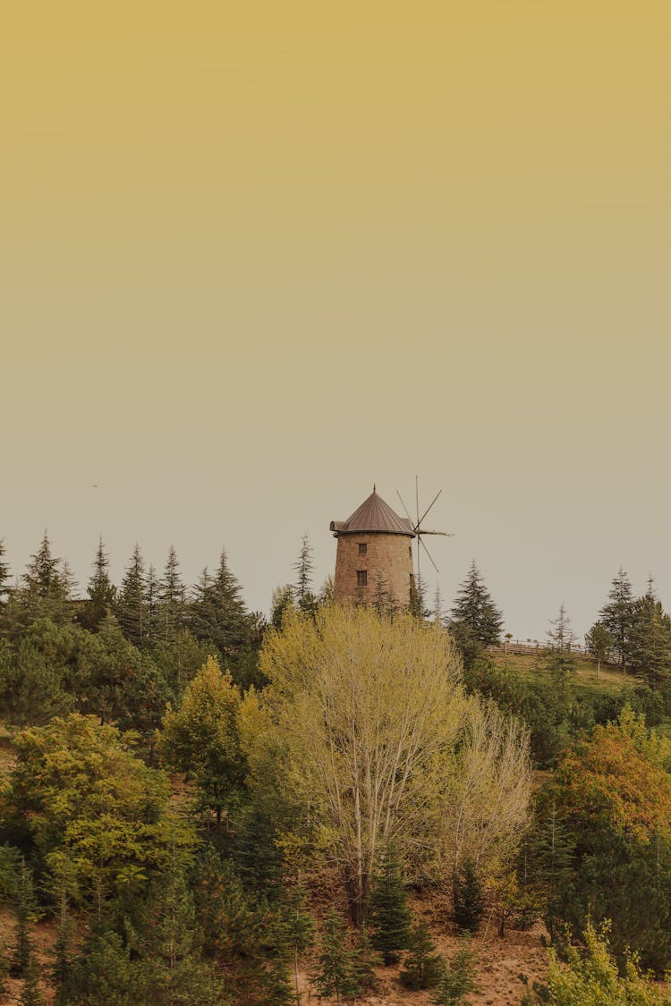 Windmill On Top Of Hill Under Yellow Sky