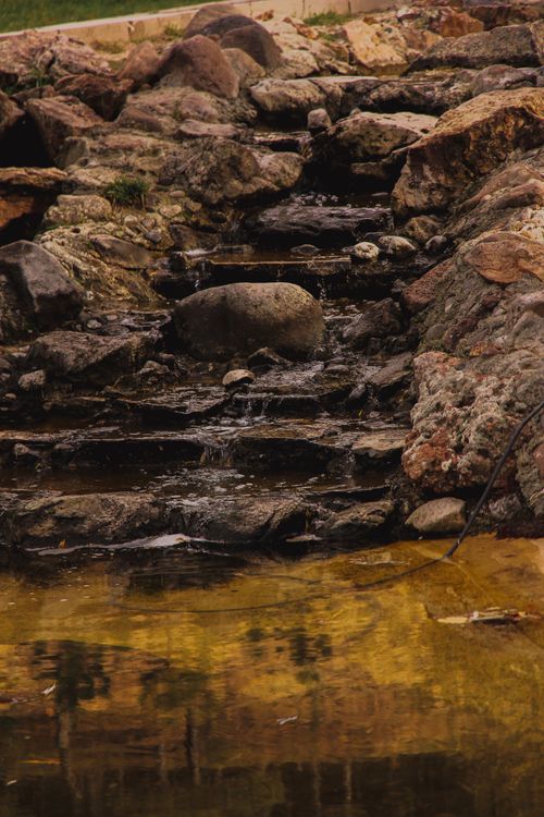 Free A tranquil scene of a rocky stream with cascading water and natural textures. Stock Photo