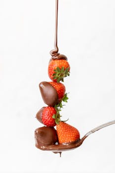 A tempting stack of strawberries drizzled with melted chocolate, perfect for dessert inspiration.