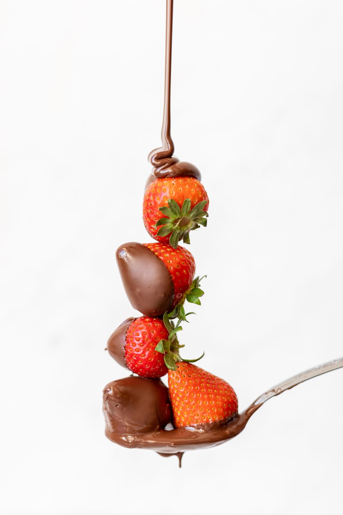 Chocolate dripping over fresh strawberries