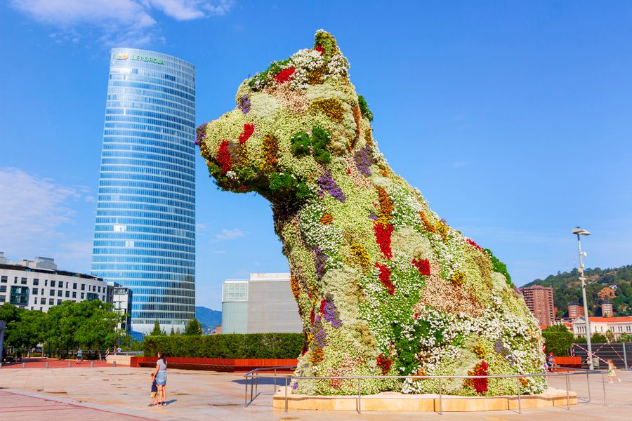 Sculptura Puppy de Jeff Koons acoperită cu flori în fața Guggenheim Bilbao