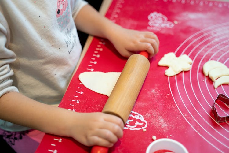 A Person Flattening A Dough 