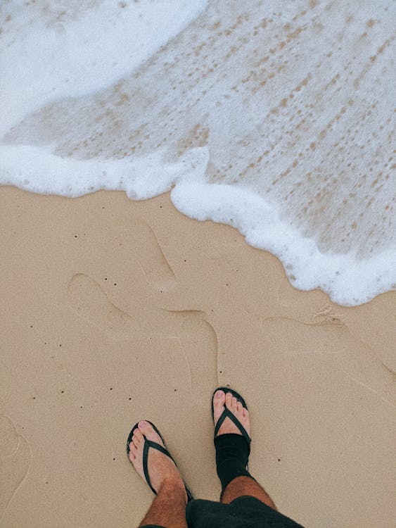 Person Standing on Beach Sand · Free Stock Photo