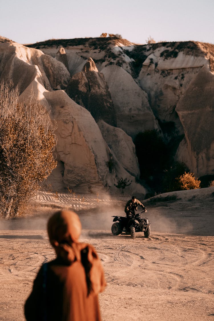 Man On ATV In Desert Mountain Landscape