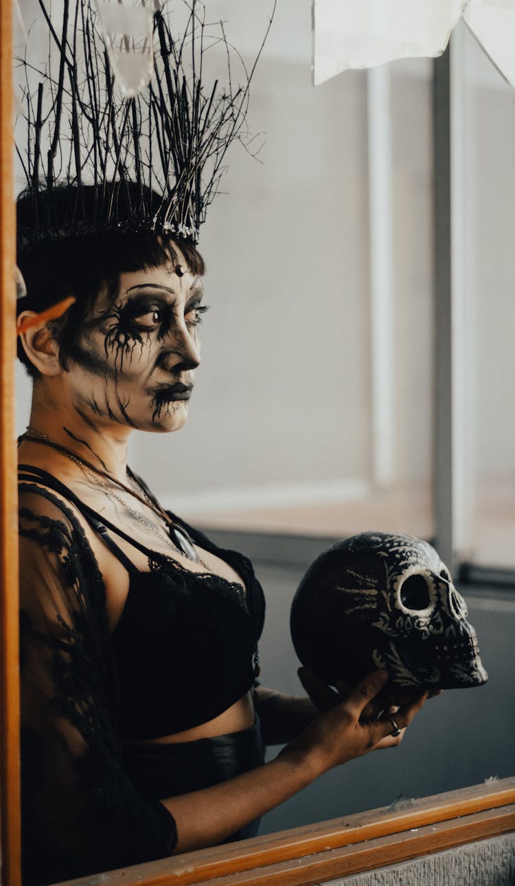 Woman In Halloween Makeup Holding Skull