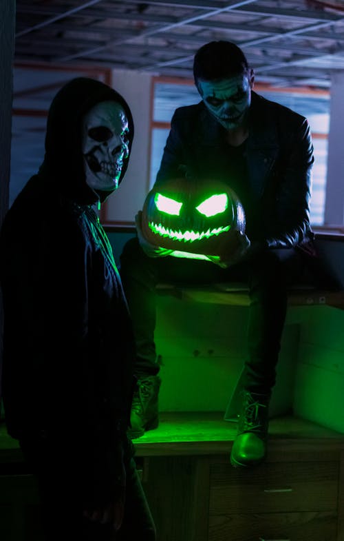 Men in Halloween Skull Makeup Holding a Pumpkin 