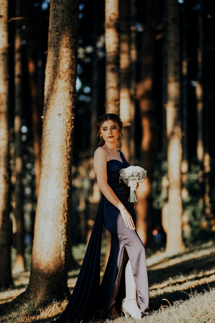 Woman In Gown Posing In Forest